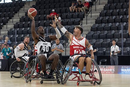 U.S. Army Master Sgt. Earlie Brown attempts to shoot over a defender in the wheelchair basketball game against Team Marine Corps during the 2025 Department of Defense Warrior Games at Colorado Springs, Colorado, July 19, 2025.