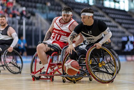Retired U.S. Army Spc. JP Lane brings the ball up court while fighting for position in the wheelchair basketball game against Team Marine Corps during the 2025 Department of Defense Warrior Games at Colorado Springs, Colorado, July 19, 2025.