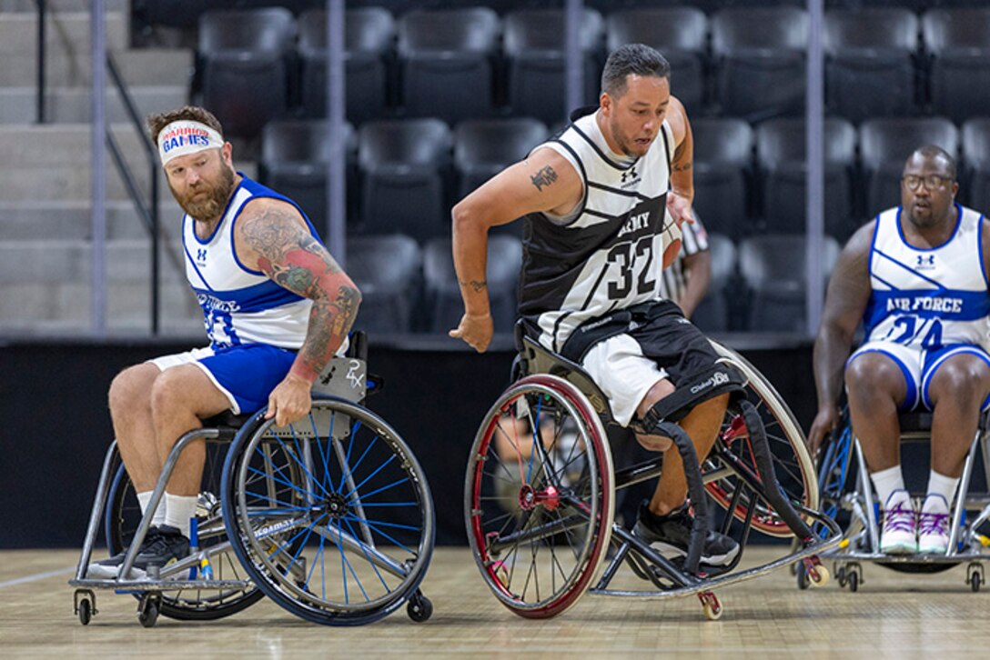 U.S. Army Spc. Anthony Farve brings the ball up court, losing a defender with a behind the back crossover, side wheelie, in the wheelchair basketball game against Team Air Force during the 2025 Department of Defense Warrior Games at Colorado Springs, Colorado, July 19, 2025.