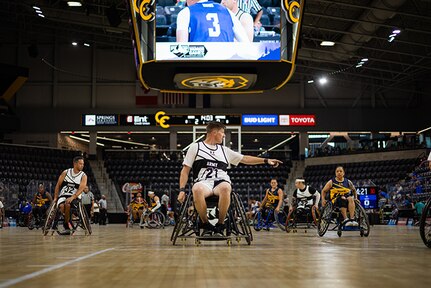 U.S. Army Staff Sgt. Coty Tuck signals for a defender during the wheelchair basketball game against Team Navy during the 2025 Department of Defense Warrior Games at Colorado Springs Colorado, July 19, 2025.