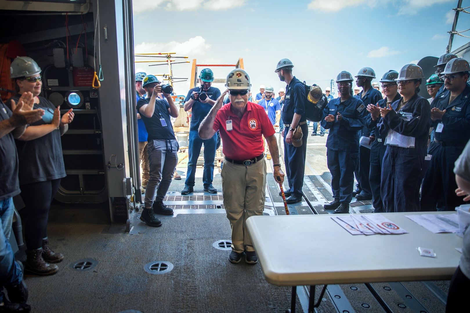BATH, Maine (July 15, 2025) – U.S. Marine Corps Col. (Ret.) Harvey C. Barnum Jr., a Medal of Honor recipient, is welcomed into the hangar by the crew of the future USS Harvey C. Barnum Jr. (DDG 124) during Alpha Trials. The ship is named in honor of Barnum, who received the Medal of Honor for valor during the Vietnam War. (U.S. Navy photo by Laura Lakeway)