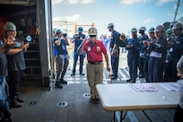 BATH, Maine (July 15, 2025) – U.S. Marine Corps Col. (Ret.) Harvey C. Barnum Jr., a Medal of Honor recipient, is welcomed into the hangar by the crew of the future USS Harvey C. Barnum Jr. (DDG 124) during Alpha Trials. The ship is named in honor of Barnum, who received the Medal of Honor for valor during the Vietnam War. (U.S. Navy photo by Laura Lakeway)