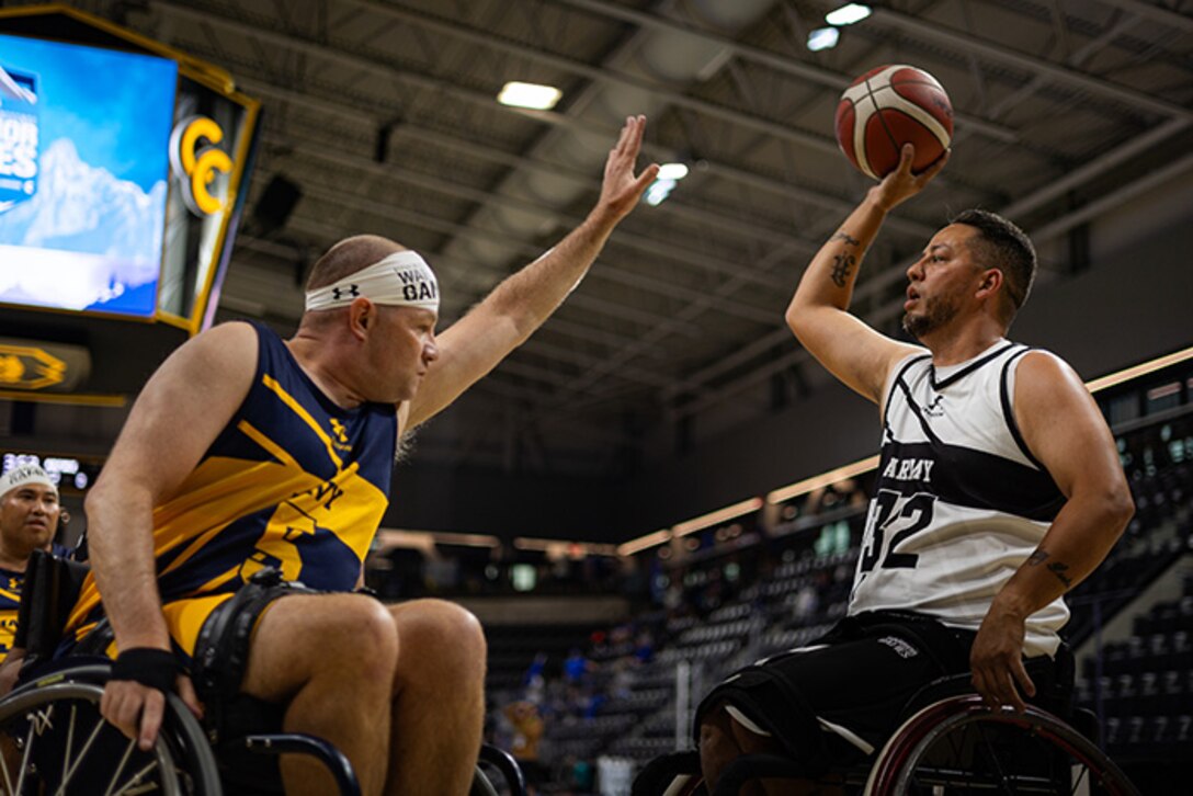 Retired U.S. Army Spc. Anthony Farve looks to pass the ball during the wheelchair basketball game against Team Navy at the 2025 Department of Defense Warrior Games at Colorado Springs Colorado, July 19, 2025.