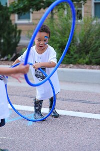 A child maneuvers through a hula hoop during the Limitless Lanes event on July 18, 2025, in Colorado Springs, Colorado.