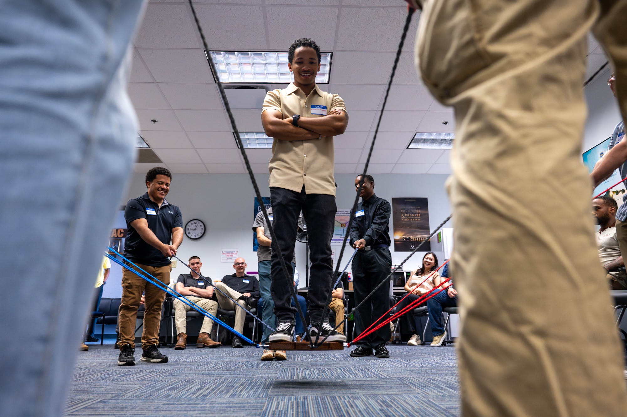 Airman 1st Class Greyson Broussard-Tavares, 375th Communications Squadron, balances on a suspended platform as fellow Airmen support him with color-coded cords during a Wingman Guardian Connect exercise.