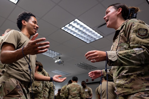Airmen work in pairs to untie themselves in an activity in the WGC FTEC.