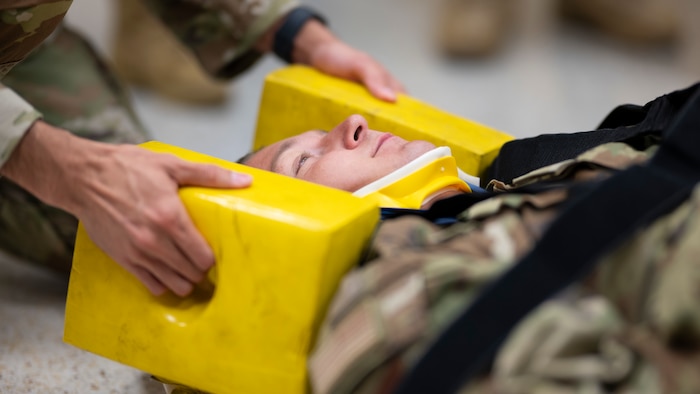 U.S. Air Force Tech. Sgt. Felix Kietur, 49th Operational Medical Readiness Squadron NCO in charge of medical maintenance, helps demonstrate how a patient is stabilized in the vent of a possible spinal injury during a Medic-X exercise at Holloman Air Force Base, New Mexico, July 16, 2025.