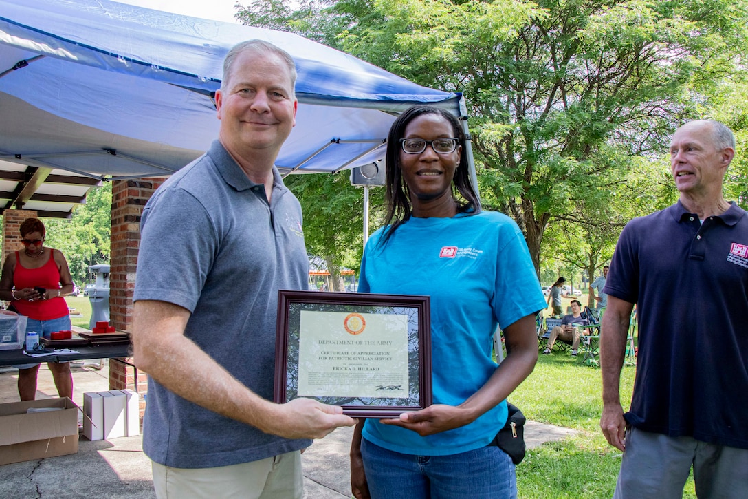 Women and man pose together holding an award certificate.