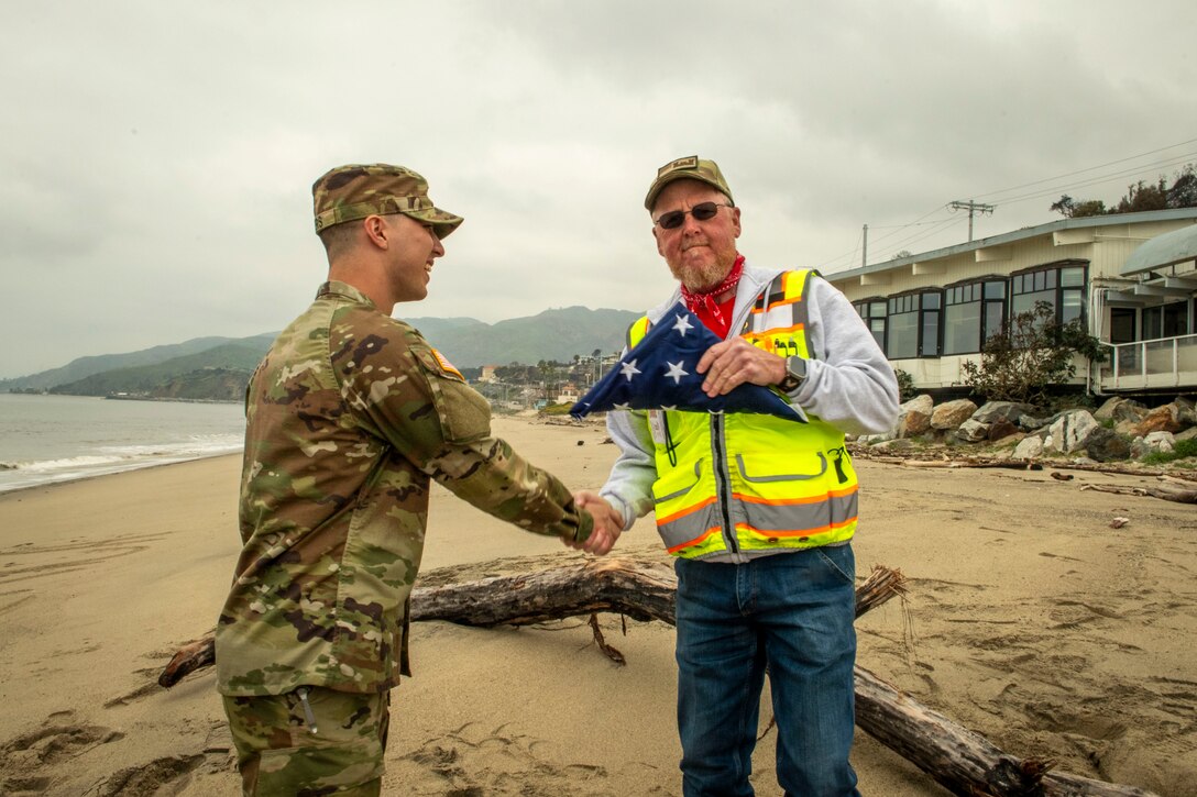 Capt. Nathan Myers shakes safety specialist Dale Beaty's hand while on deployment for the Southern California Wildfire Response mission.