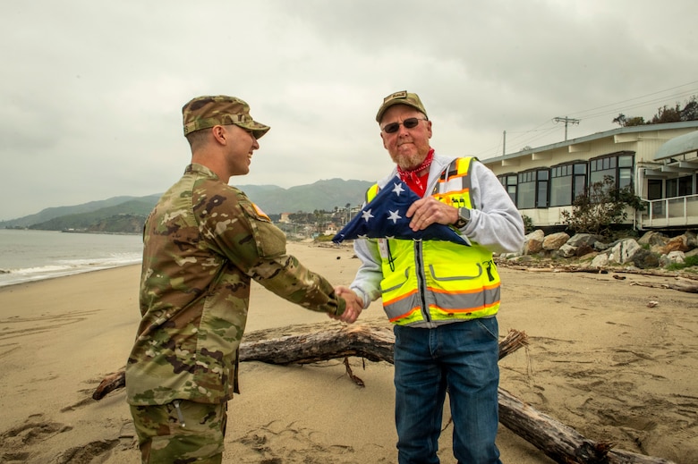 Capt. Nathan Myers shakes safety specialist Dale Beaty's hand while on deployment for the Southern California Wildfire Response mission.