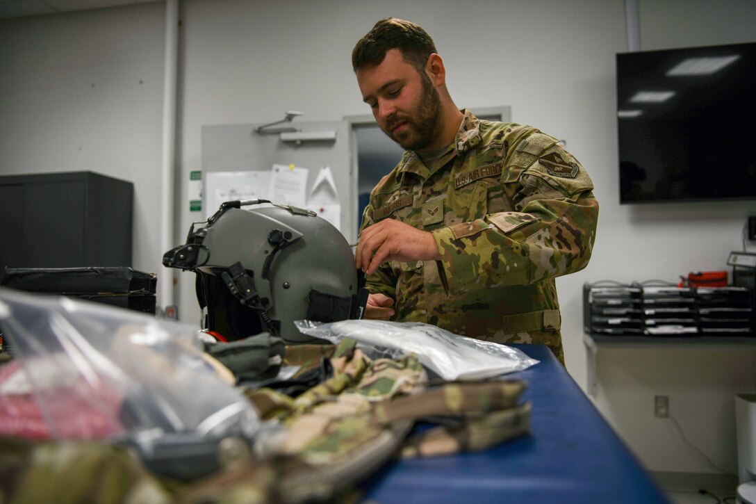 A service member fixes a flight helmet.