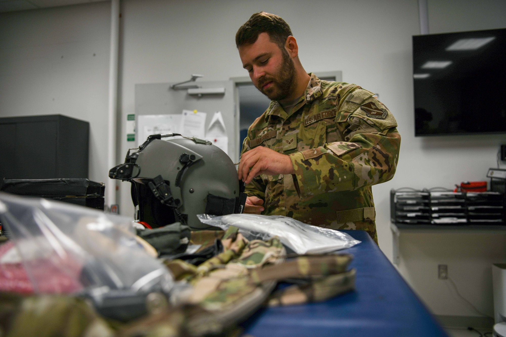 A service member fixes a flight helmet.