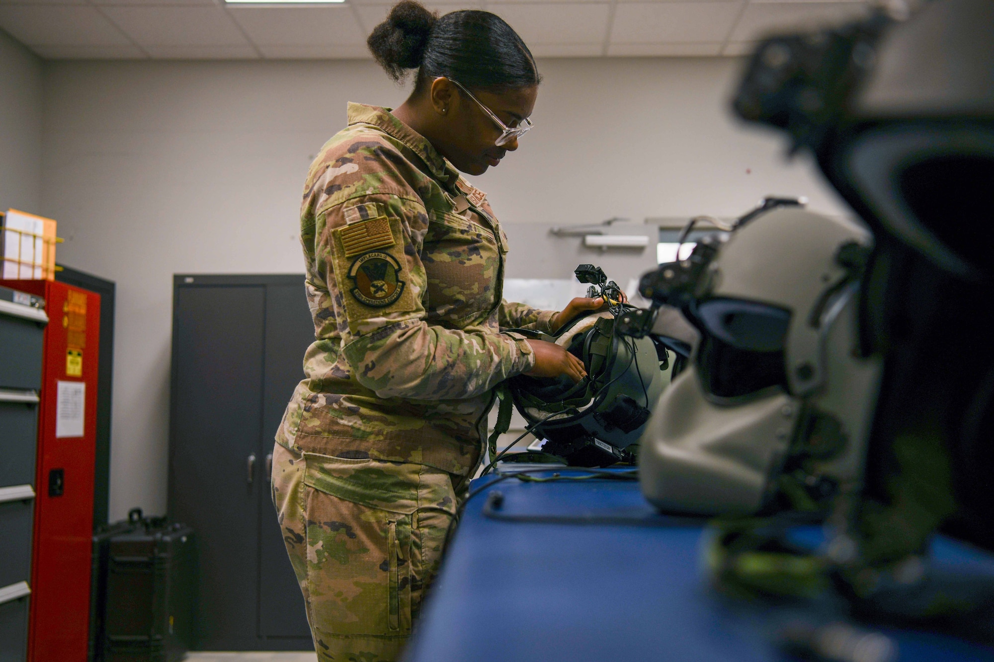 A service member inspects a flying helmet.