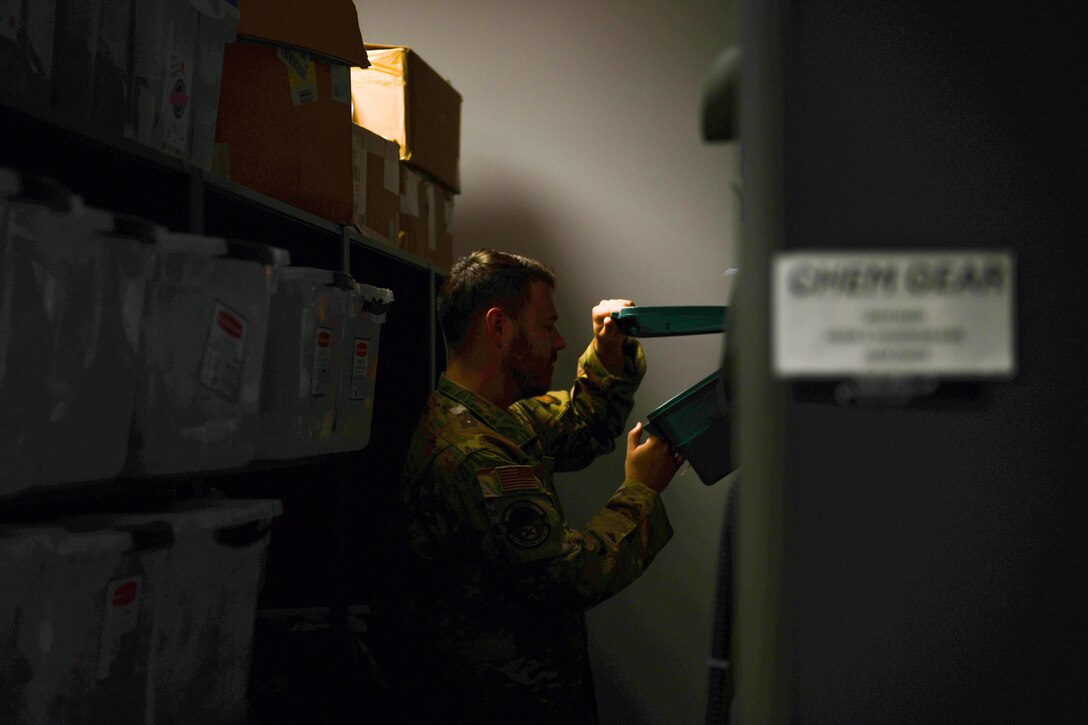 Airman looks in an equipment box.