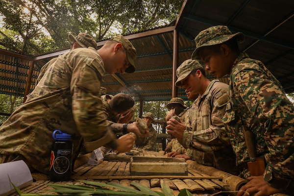 Malaysian Army soldiers demonstrate how to start a fire using natural materials found in the jungle, an essential survival skill shared with their Australian and U.S. Army partners during field training July 20, 2025.