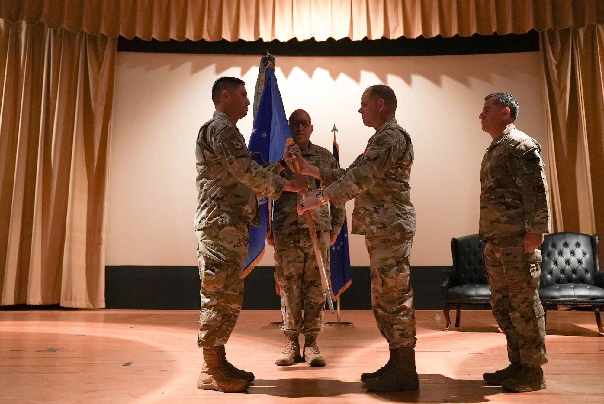 U.S. Air Force Chief Master Sgt. Colin Fleck (right), outgoing 27th Special Operations Wing command chief, passes the guidon to Col. Robert Johnston (left), 27th SOW commander, during a change of responsibility ceremony at Cannon Air Force Base, New Mexico, July 21, 2025. During his tenure as command chief, Fleck oversaw the largest alert deployment in 27th SOW history and numerous quality-of-life improvements across the base. (U.S. Air Force photo by Staff Sgt. Kevin Williams)