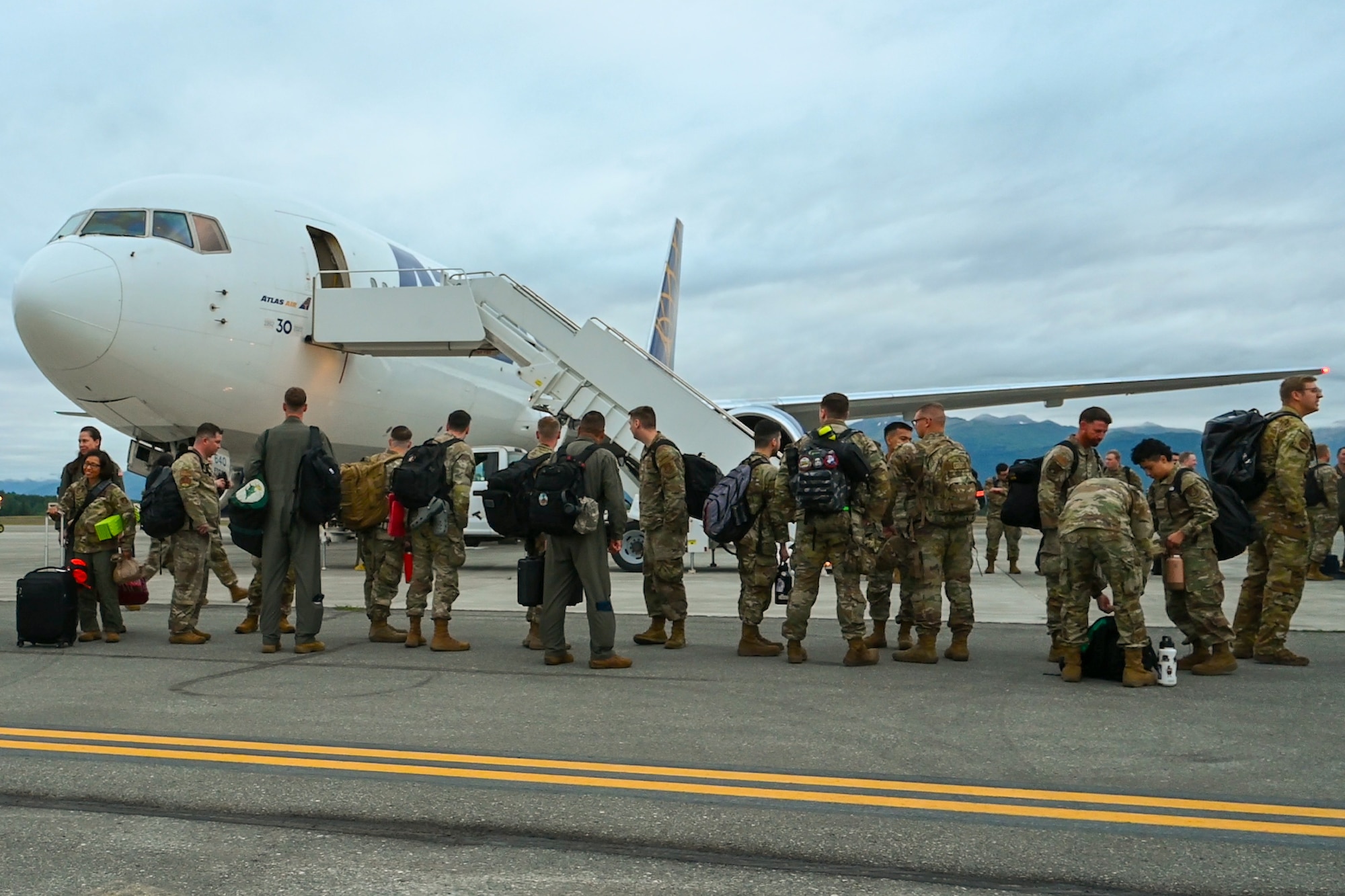 U.S. Air Force Airmen assigned to the 3rd Air Expeditionary Wing prepare to board an aircraft in support of exercise Resolute Force Pacific at Joint Base Elmendorf-Richardson, Alaska, July 13, 2025.