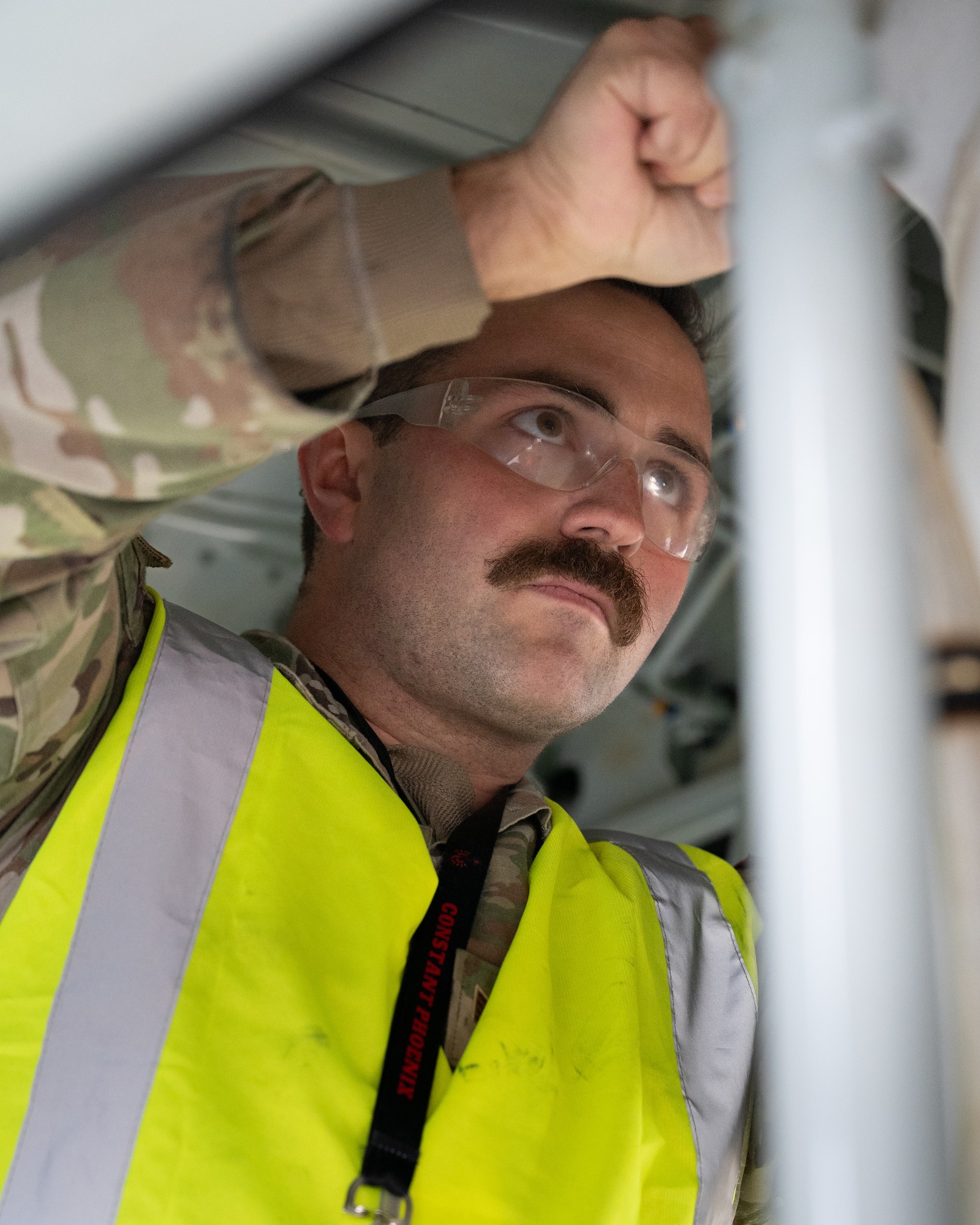 An RC-135V/W Rivet Joint crew chief preps to fill a strut with nitrogen.