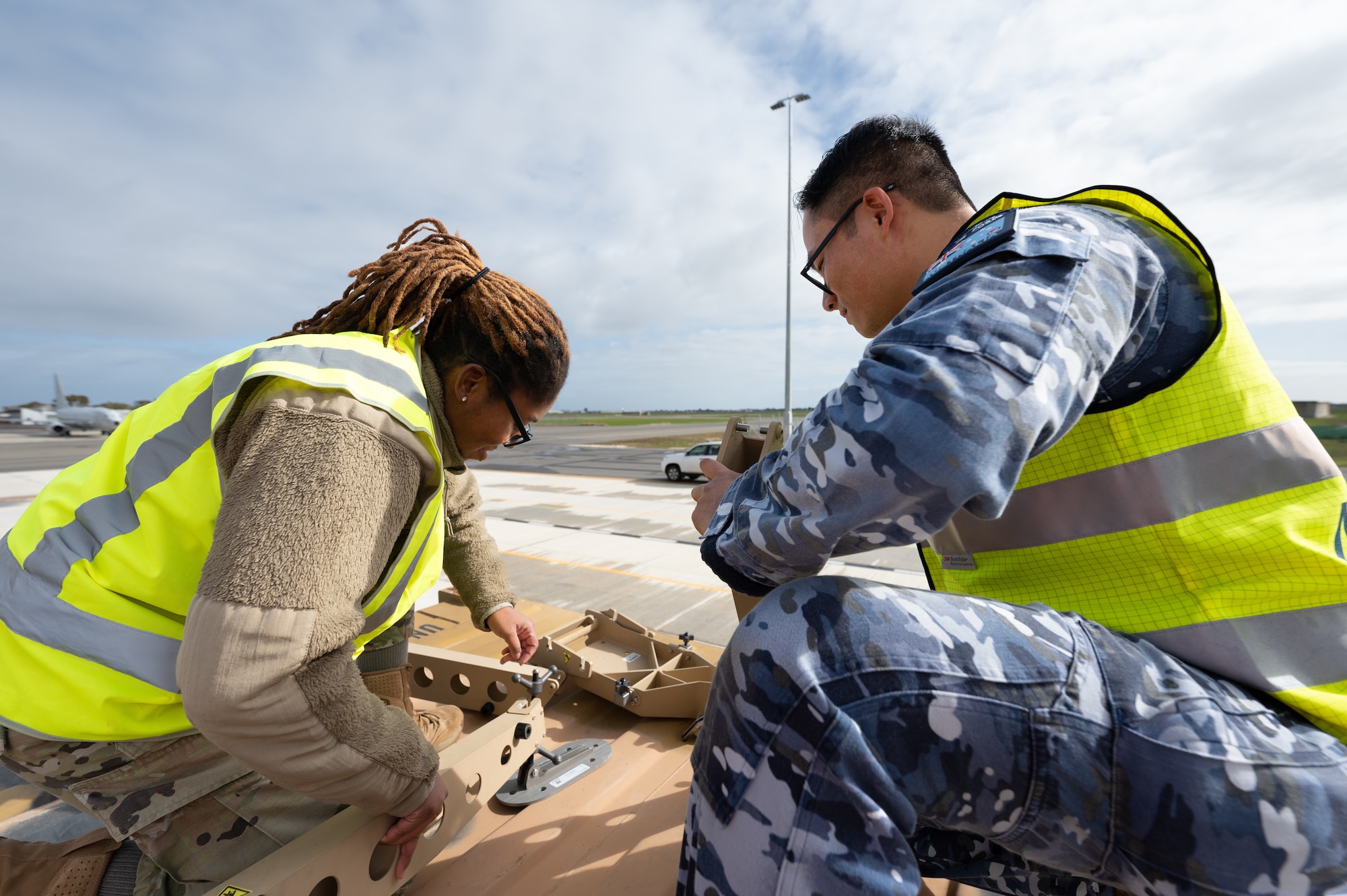 USAF and RAAF communications technicians set up a satellite dish.