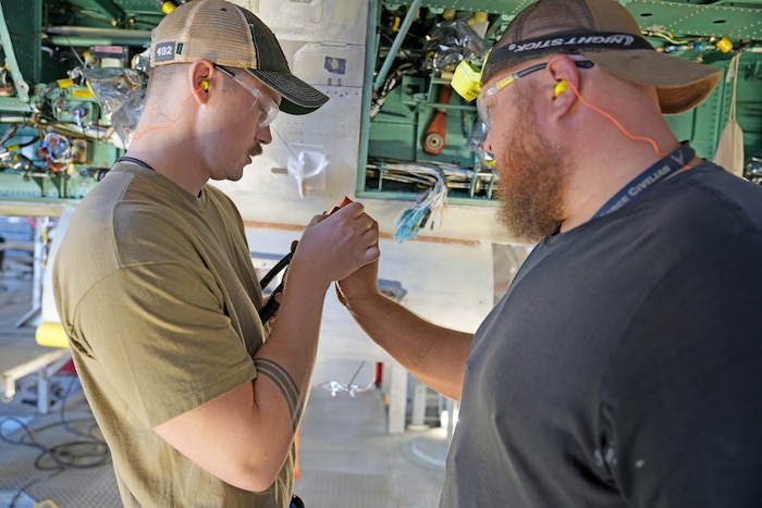 mechanics working on a fighter aircraft