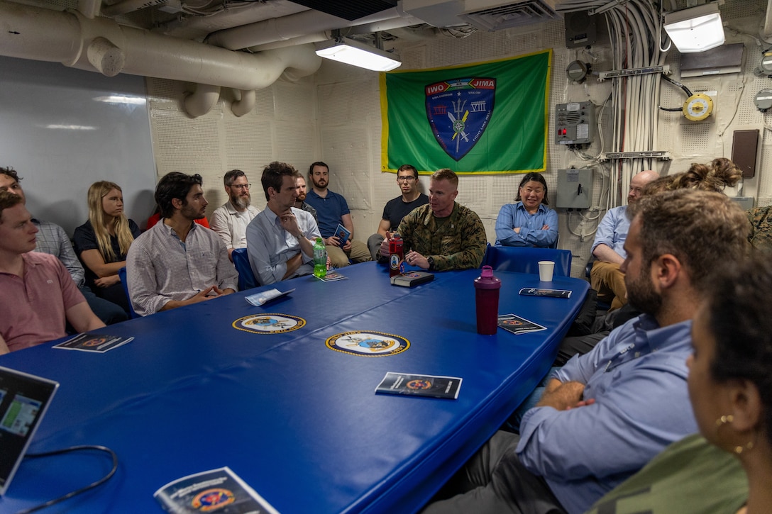 U.S. Marine Corps Col. Thomas Trimble, Commanding Officer of 22nd Marine Expeditionary Unit (Special Operations Capable) discusses 22nd MEU(SOC) capabilities with Office of Secretary of Defense staff during their visit aboard the Wasp-class amphibious assault ship USS Iwo Jima (LHD 7), during Composite Training Unit Exercise while underway in the Atlantic Ocean, July 8-9, 2025. During COMPTUEX, the IWO ARG and 22nd MEU(SOC), refine tactics, techniques, and procedures to execute warfighting functions that enhance operational readiness and lethality as a unified IWOARG/22MEU(SOC) team. (U.S. Marine Corps photo by Cpl. Emily Hazelbaker)