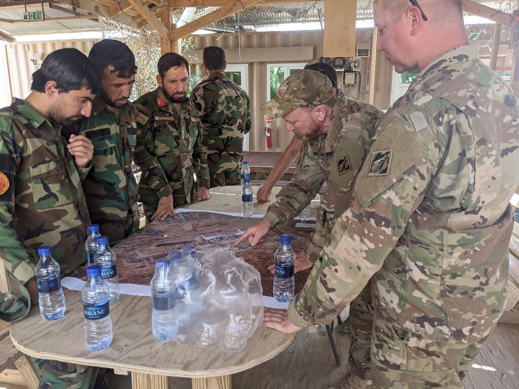 Afghan National Army soldiers speak through an interpreter with U.S. Army Corps of Engineers civilian contracting officer technical representative, Ryan Williams, who explains the operation of the power plant and electrical grid at Forward Operating Base Dwyer in Helmand province, Afghanistan, in late May 2021. The two-day training, conducted under U.S. Army supervision, came during the final weeks before the base’s closure as part of the U.S. withdrawal. (U.S. Army Photo by Ryan Williams)
