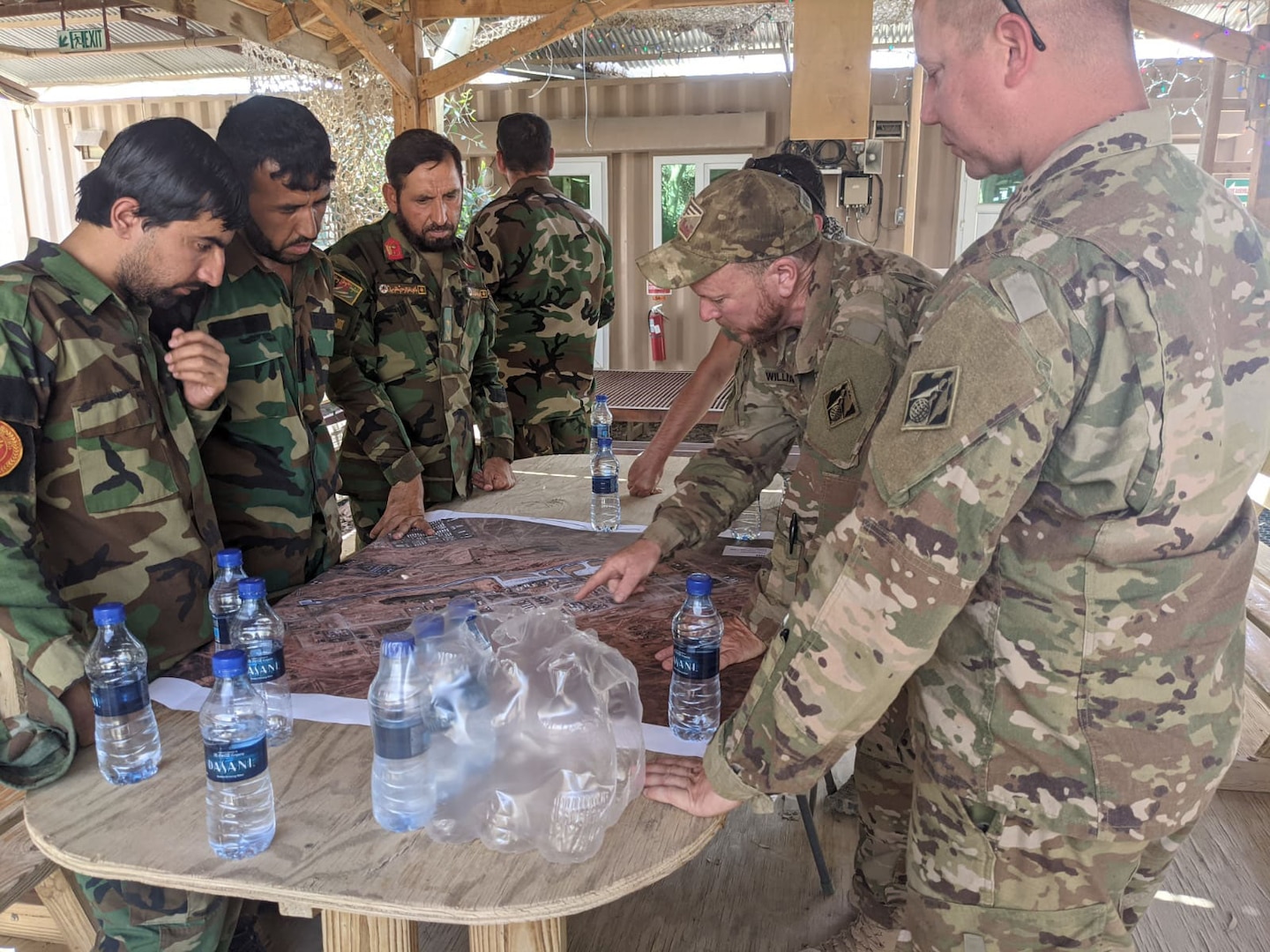 Afghan National Army soldiers speak through an interpreter with U.S. Army Corps of Engineers civilian contracting officer technical representative, Ryan Williams, who explains the operation of the power plant and electrical grid at Forward Operating Base Dwyer in Helmand province, Afghanistan, in late May 2021. The two-day training, conducted under U.S. Army supervision, came during the final weeks before the base’s closure as part of the U.S. withdrawal. (U.S. Army Photo by Ryan Williams)
