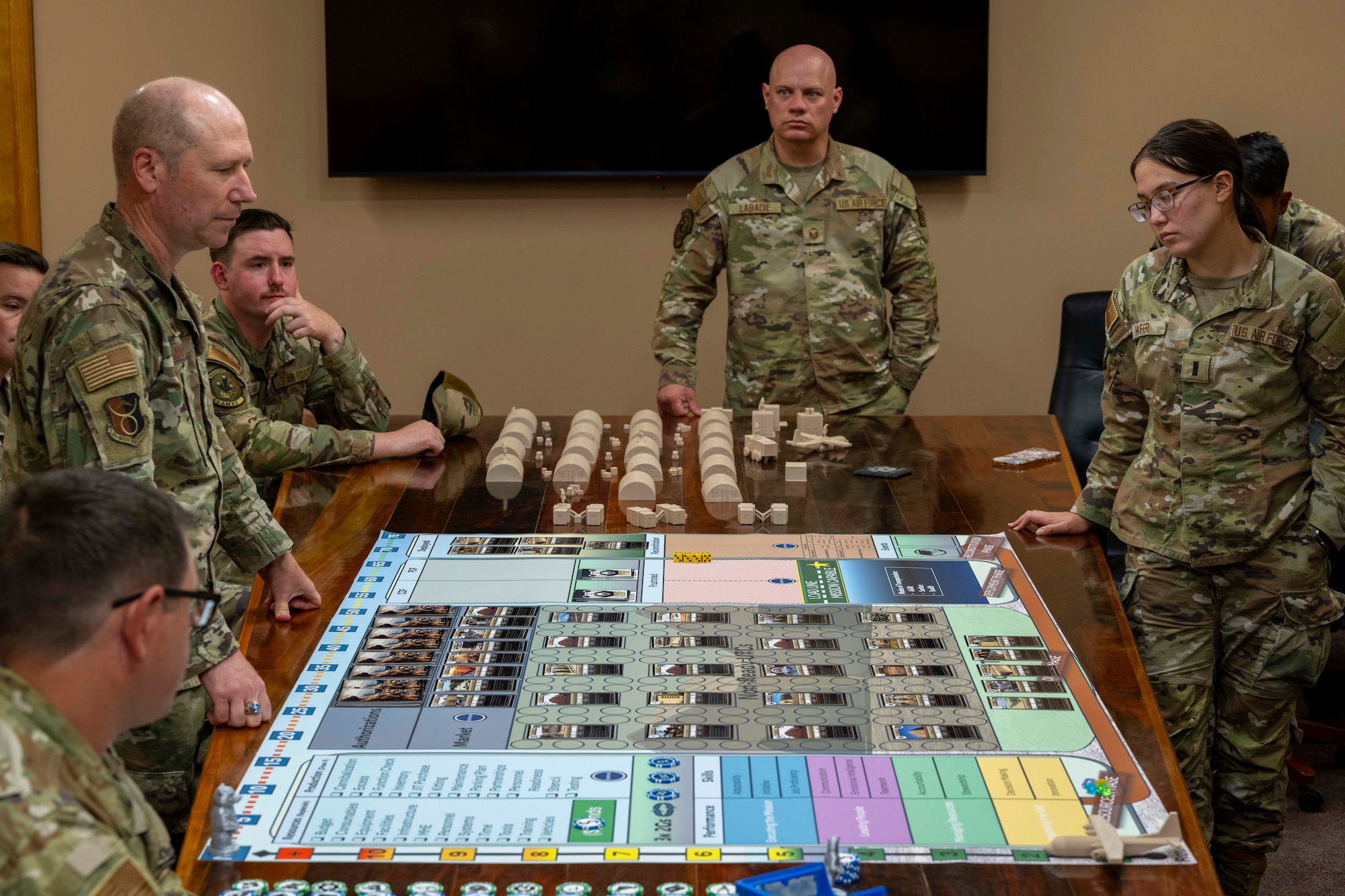 Military personnel working on a wargame board that looks similar to a boardgame.