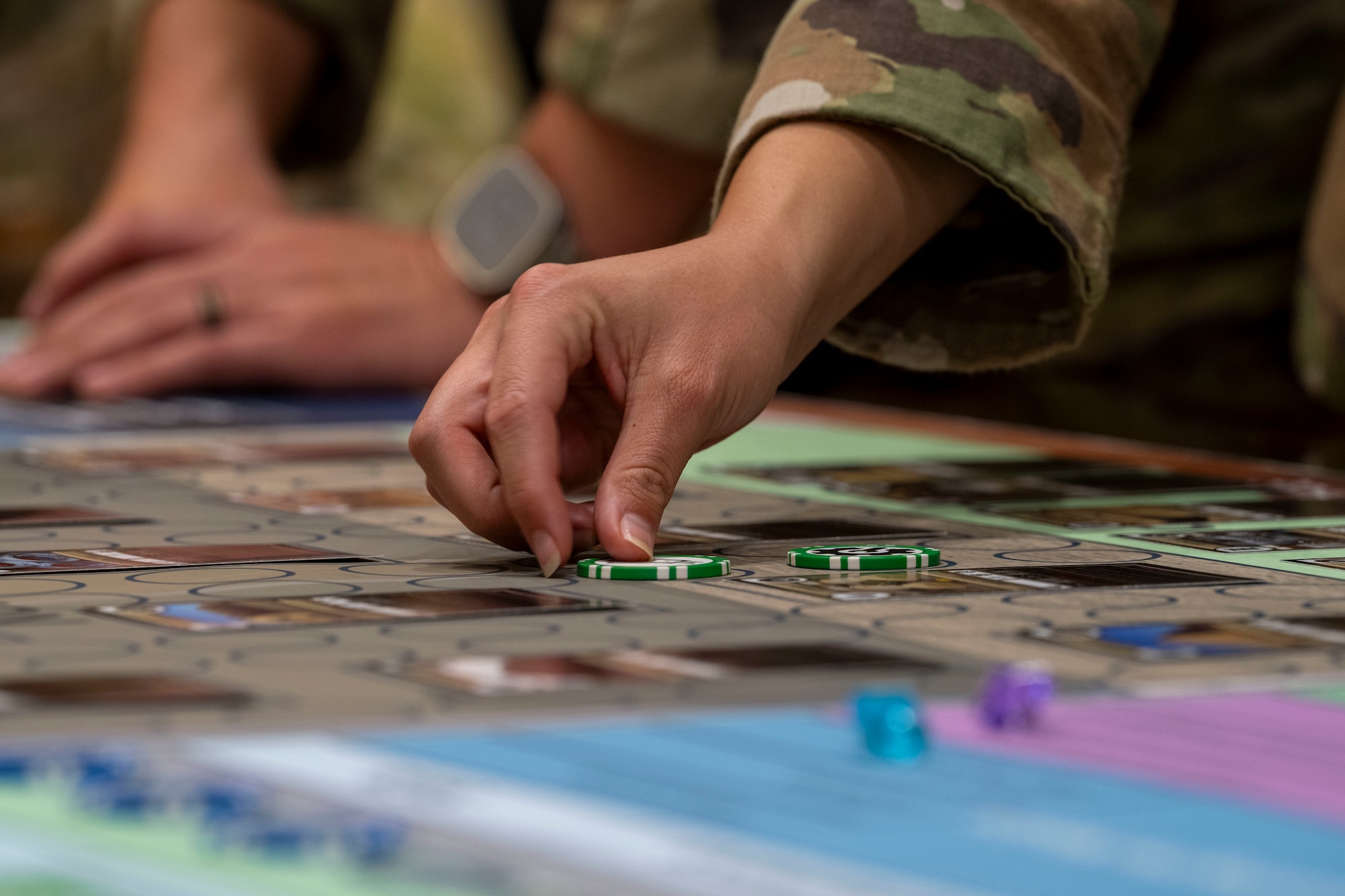 Military personnel working on a wargame board that looks similar to a boardgame.
