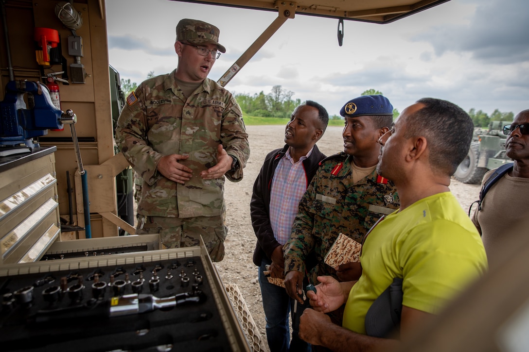 U.S. Army Sgt. Mark Dooley, the motor sergeant for the 2061st Multi-Role Bridge Company, explains the organization of maintenance contact trucks with engineer officers of the Djibouti Armed Forces (DAF) at Camp Dodge, Iowa on May 14, 2024.