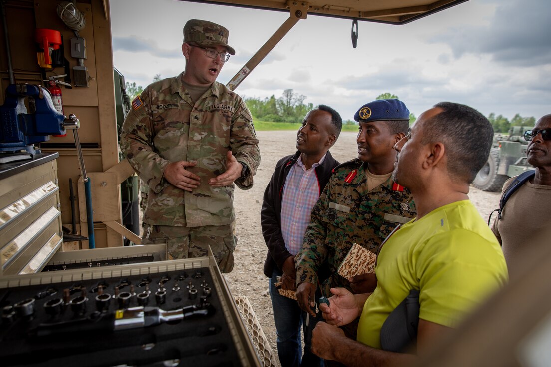 U.S. Army Sgt. Mark Dooley, the motor sergeant for the 2061st Multi-Role Bridge Company, explains the organization of maintenance contact trucks with engineer officers of the Djibouti Armed Forces (DAF) at Camp Dodge, Iowa on May 14, 2024.