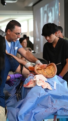 FORT LAUDERDALE, Fla. (July 12, 2025) —Dr. Aeyal Oren, a general surgeon and private practitioner in Plantation, left, uses a Tactical Combat Casualty Care Cut Suit to show internal organs during the “Top Doc” event at Nova Southeastern University’s Fort Lauderdale campus. Navy Medicine and Navy Recruiting Command partnered with NSU to launch “Top Doc”, a national initiative connecting local medical professionals, educators, and students while highlighting Navy Medicine’s capabilities and career opportunities. (U.S. Navy Photo by Mass Communication Specialist 1st Class Natalia Murillo)