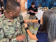 FORT LAUDERDALE, Fla. (July 12, 2025) Hospital Corpsman 1st Class Okief Robb, attached to Navy Talent Acquisition Group (NTAG) Miami, guides a participant on tourniquet application during the "Top Doc" event held at Nova Southeastern University's Fort Lauderdale campus. Navy Medicine and Navy Recruiting Command partnered with NSU to launch “Top Doc”, a national initiative connecting local medical professionals, educators, and students while highlighting Navy Medicine’s capabilities and career opportunities. (U.S. Navy Photo by Mass Communication Specialist 1st Class Natalia Murillo)