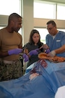 FORT LAUDERDALE, Fla. (July 12, 2025) Lt. Cmdr. Daniel Johnson, an orthopedic surgeon with Navy Medicine Readiness and Training Command Jacksonville, left, and Dr. Aeyal Oren, a general surgeon in private practice in Plantation, right, use a Tactical Combat Casualty Care Cut Suit to demonstrate emergency abdominal surgery to a participant during the “Top Doc” event at Nova Southeastern University’s Fort Lauderdale campus. Navy Medicine and Navy Recruiting Command partnered with NSU to launch “Top Doc”, a national initiative connecting local medical professionals, educators, and students while highlighting Navy Medicine’s capabilities and career opportunities. (U.S. Navy Photo by Mass Communication Specialist 1st Class Natalia Murillo)