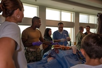 FORT LAUDERDALE, Fla. (July 12, 2025) Lt. Cmdr. Daniel Johnson, an orthopedic surgeon with Navy Medicine Readiness and Training Command Jacksonville, left, and Dr. Aeyal Oren, a general surgeon in private practice in Plantation, right, use a Tactical Combat Casualty Care Cut Suit to demonstrate emergency abdominal surgery during the “Top Doc” event at Nova Southeastern University’s Fort Lauderdale campus. Navy Medicine and Navy Recruiting Command partnered with NSU to launch “Top Doc”, a national initiative connecting local medical professionals, educators, and students while highlighting Navy Medicine’s capabilities and career opportunities. (U.S. Navy Photo by Mass Communication Specialist 1st Class Natalia Murillo)