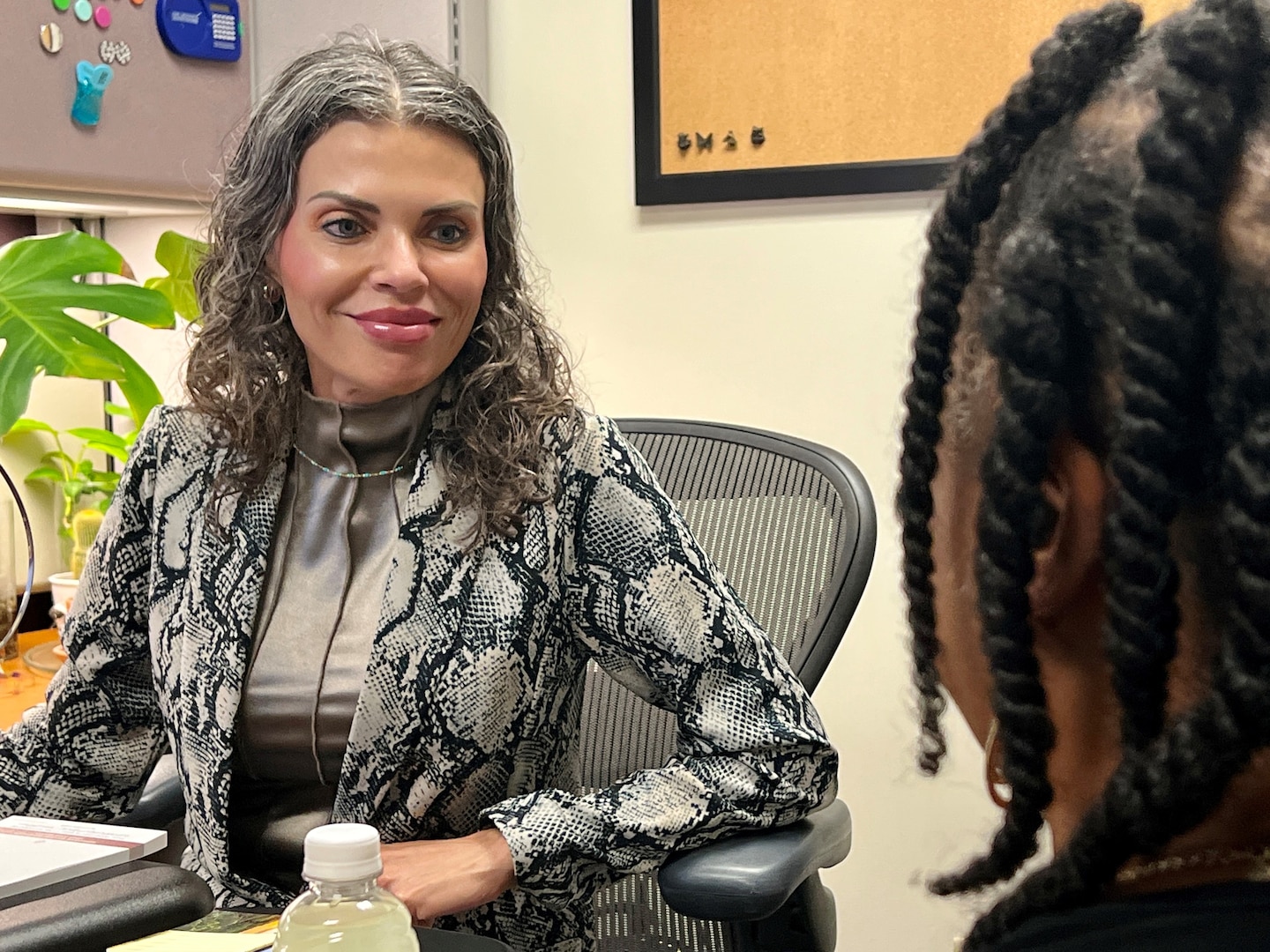 Woman sitting behind desk talking to a female patient.
