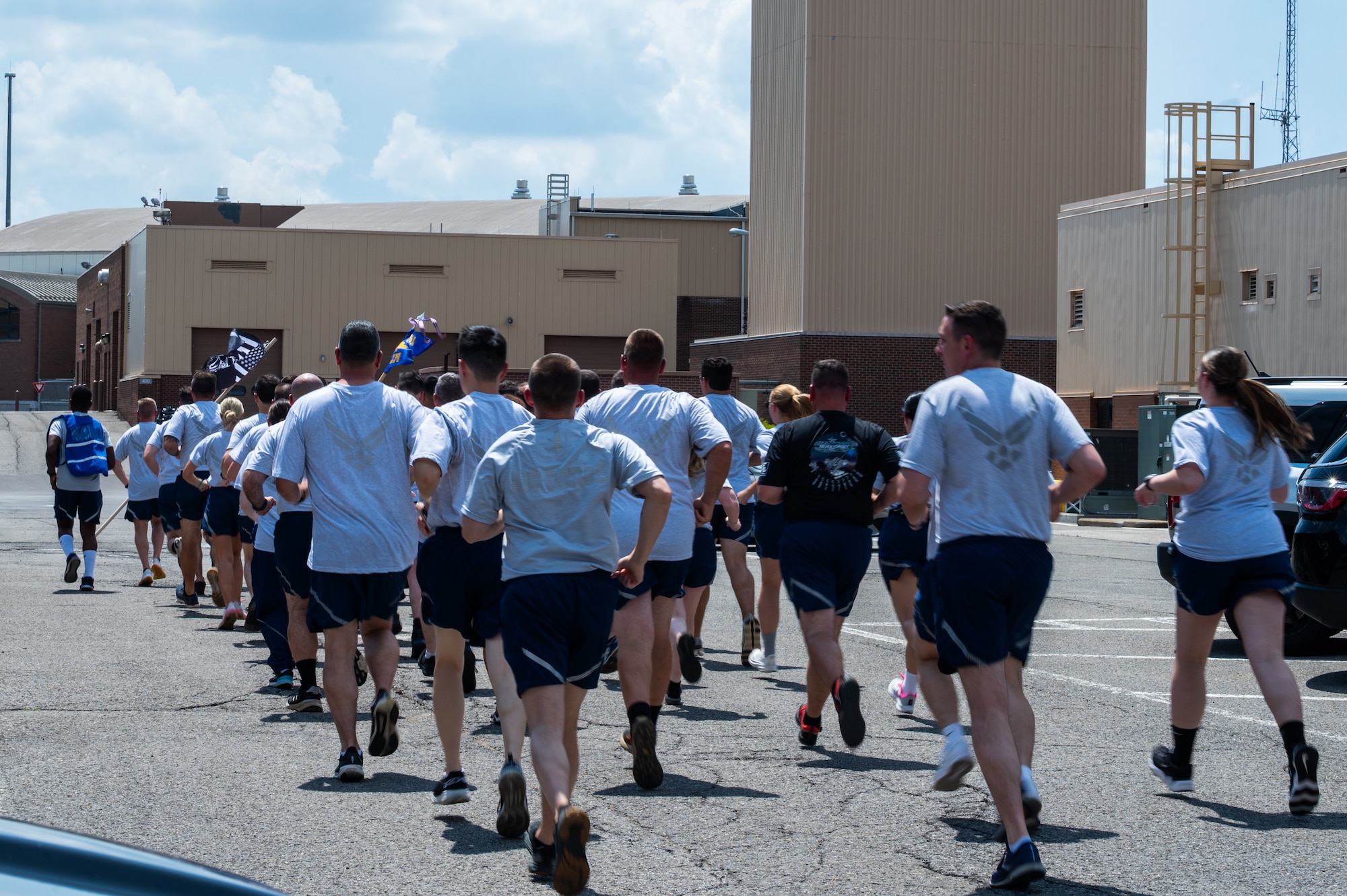 A group of Airmen in PT gear run down a road.