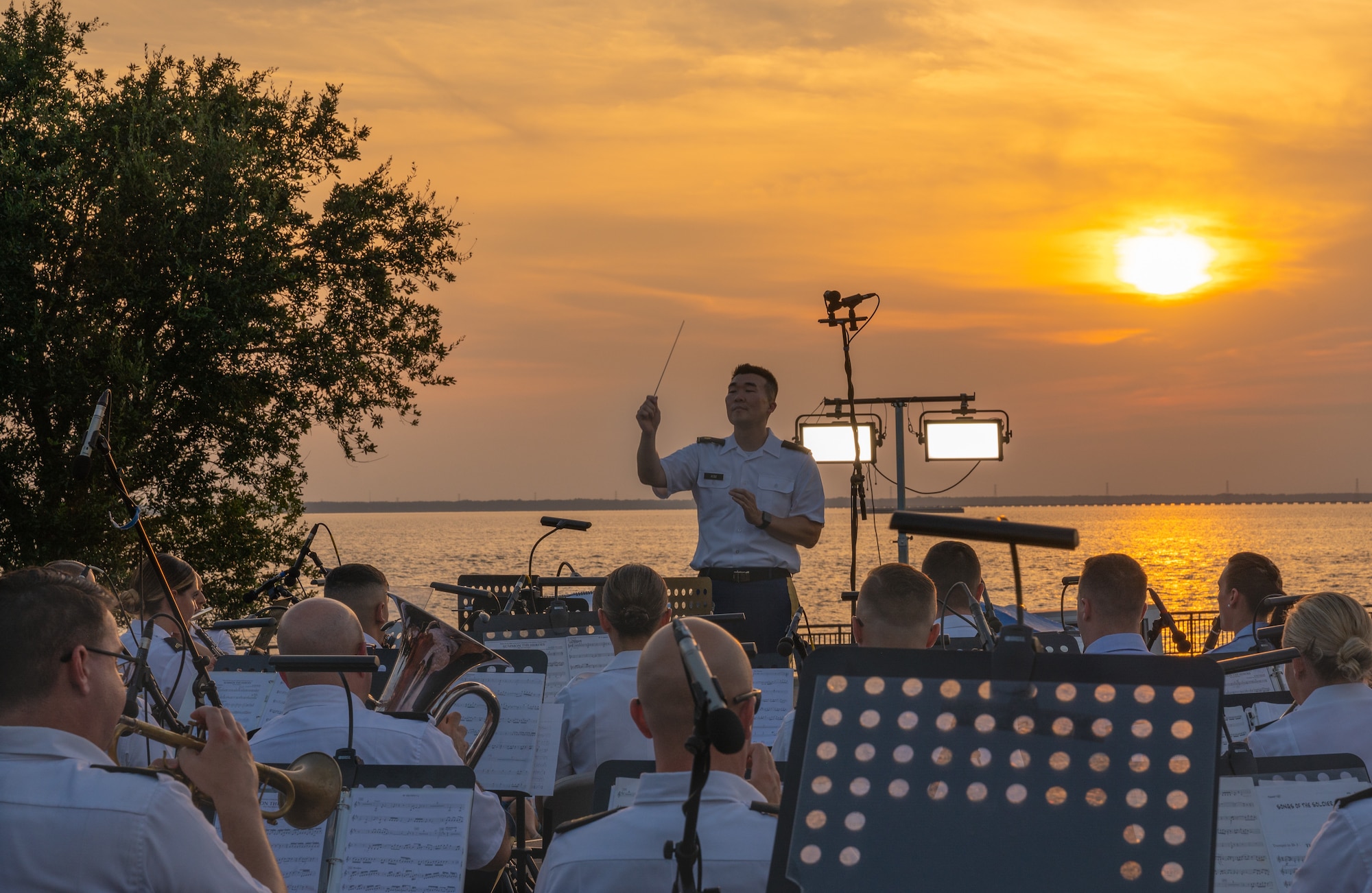 A man conducts the band sitting in front of him.