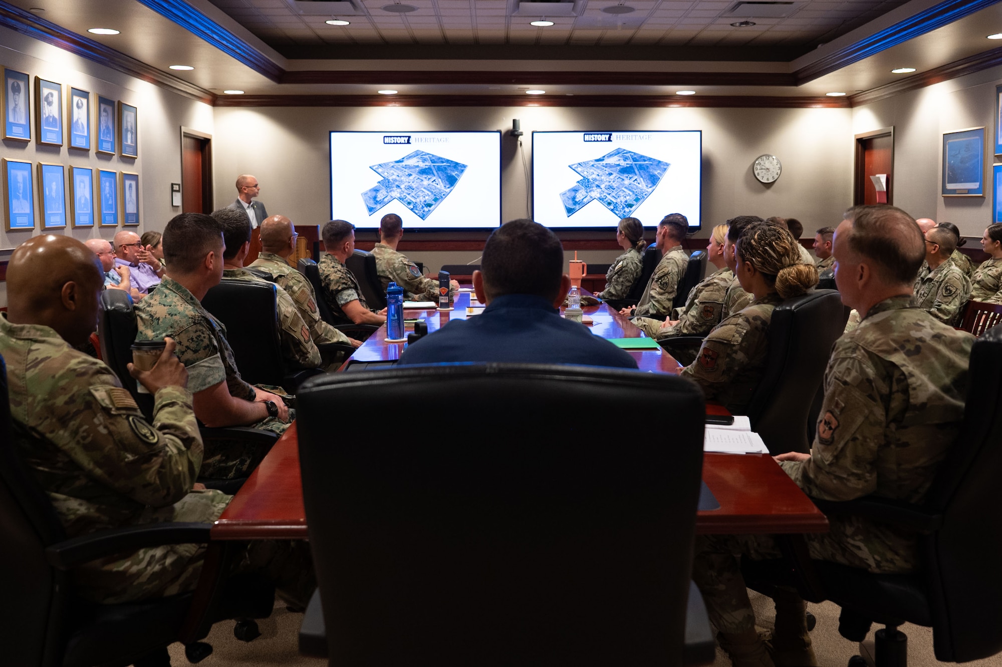 U.S. Coast Guard Rear Adm. Greg Rothrock, U.S. Cyber Command J7 Director of Force Development, and U.S. Air Force Chief Master Sgt. Kenneth Bruce, Command Senior Enlisted Leader, USCYBERCOM and Director's Senior Enlisted Advisor, National Security Agency/Commander’s Support Staff, receive the 17th Training Wing Mission Brief at the Norma Brown headquarters building, Goodfellow Air Force Base, Texas, May 20, 2025. The Wing Mission Brief introduces visitors to each of the groups and squadrons that fall under the 17th TRW, including geographically separated units, and explains how their operations support the mission. (U.S. Air Force photo by Airman 1st Class Brian Lummus)