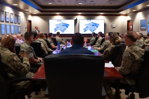 U.S. Coast Guard Rear Adm. Greg Rothrock, U.S. Cyber Command J7 Director of Force Development, and U.S. Air Force Chief Master Sgt. Kenneth Bruce, Command Senior Enlisted Leader, USCYBERCOM and Director's Senior Enlisted Advisor, National Security Agency/Commander’s Support Staff, receive the 17th Training Wing Mission Brief at the Norma Brown headquarters building, Goodfellow Air Force Base, Texas, May 20, 2025. The Wing Mission Brief introduces visitors to each of the groups and squadrons that fall under the 17th TRW, including geographically separated units, and explains how their operations support the mission. (U.S. Air Force photo by Airman 1st Class Brian Lummus)