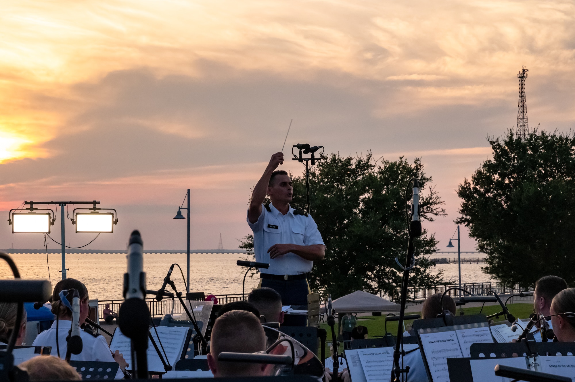 A man conducts the band sitting in front of him.