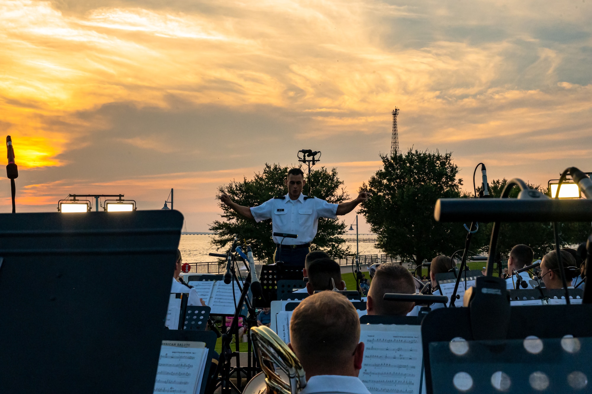 A man conducts the band sitting in front of him.