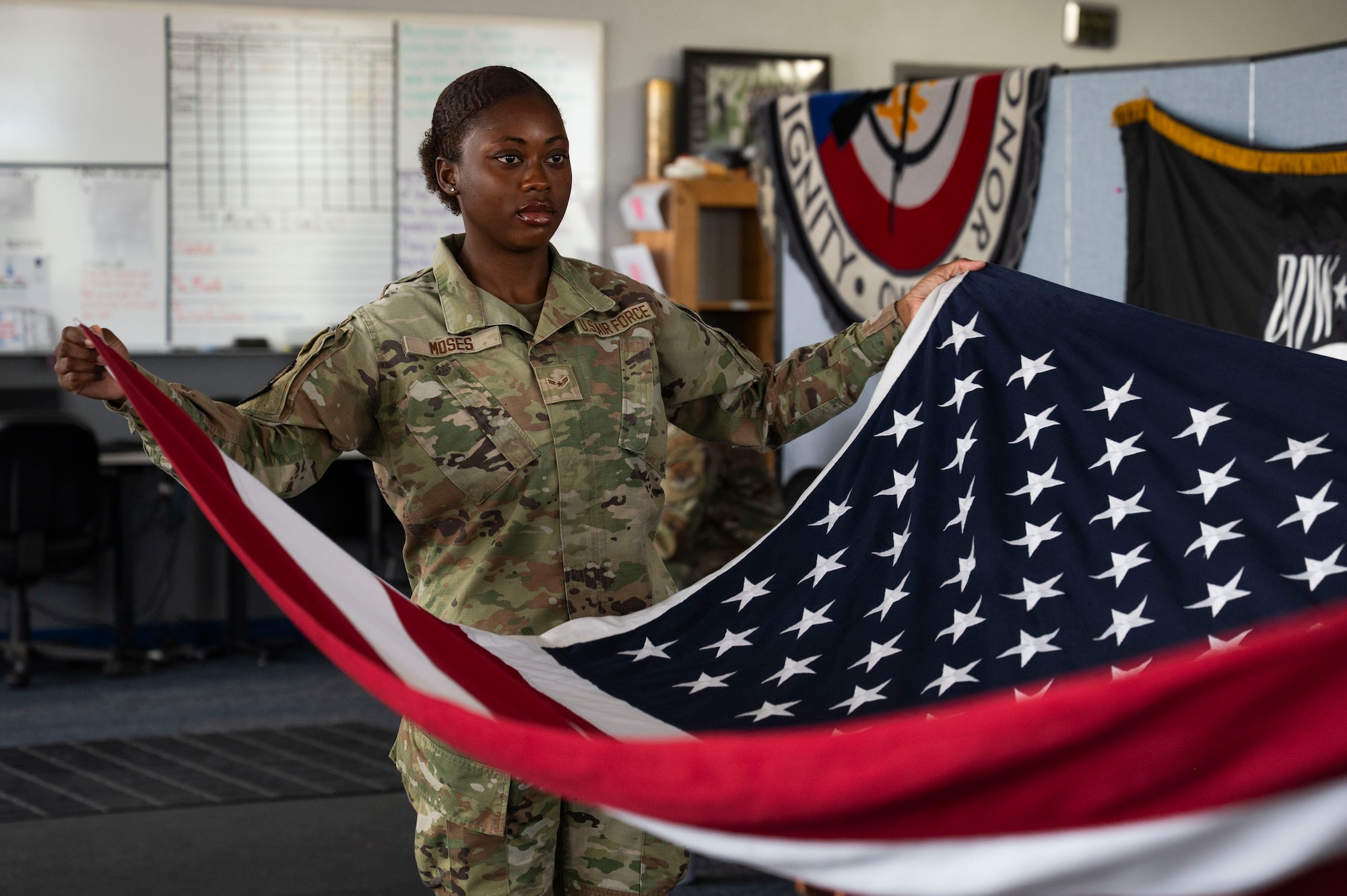 U.S. Air Force Airman 1st Class Monique Moses, an honor guardsman in training with the Davis-Monthan Air Force Base Honor Guard, practices the flag-folding technique at Davis-Monthan Air Force Base, Arizona, July 21, 2025. Each fold in the flag carries meaning and the technique is performed with precision to honor those who have served and sacrificed. (U.S. Air Force photo by Airman Samantha Melecio)