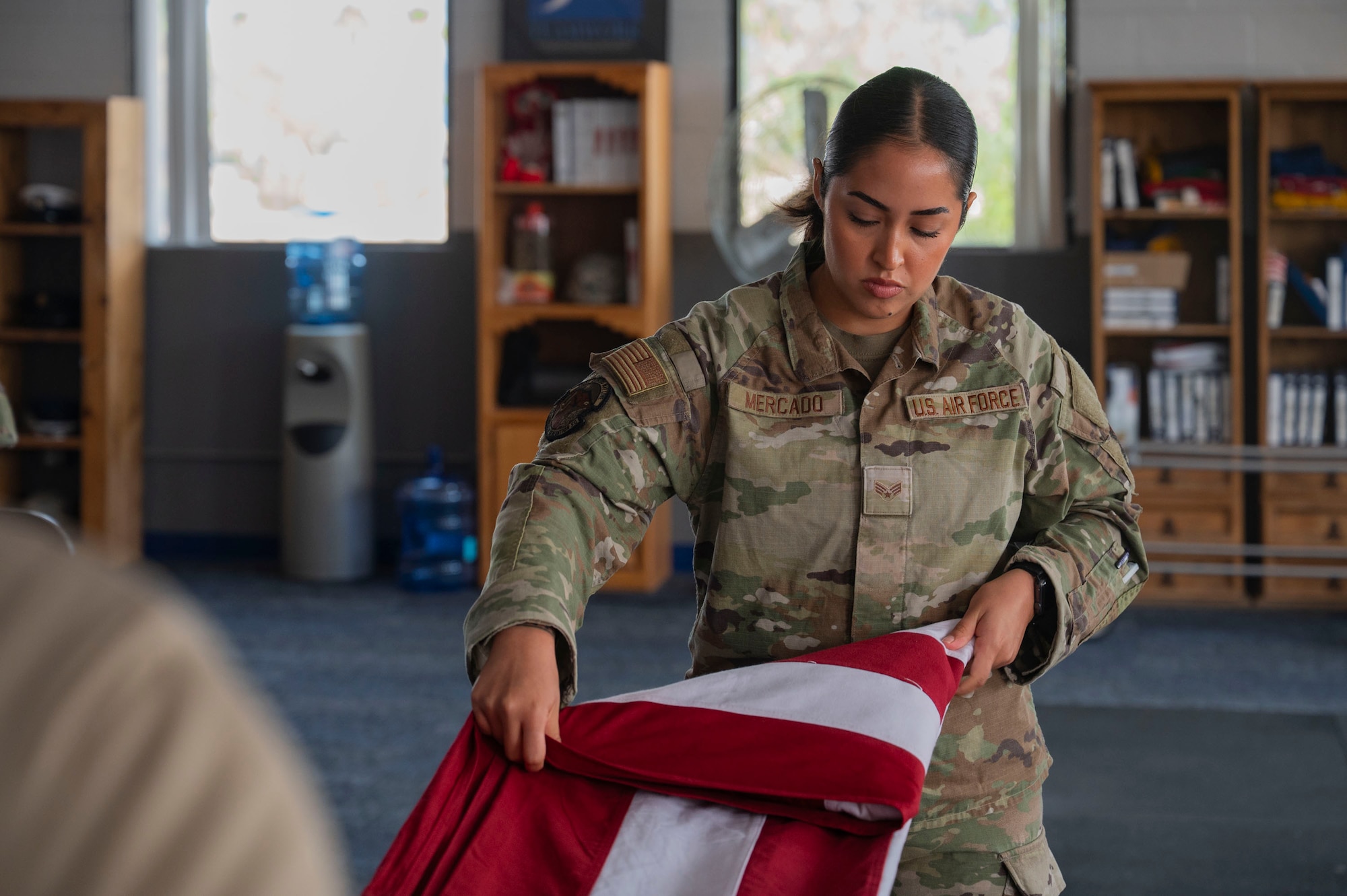 U.S. Air Force Senior Airman Melanie Mercado, an honor guardsman in training with the Davis-Monthan Air Force Base Honor Guard, practices the flag-folding technique at Davis-Monthan Air Force Base, Arizona, July 21, 2025. Used in funerals, retirements and memorials, the flag-folding technique embodies the core values of the USAF. (U.S. Air Force photo by Airman Samantha Melecio)