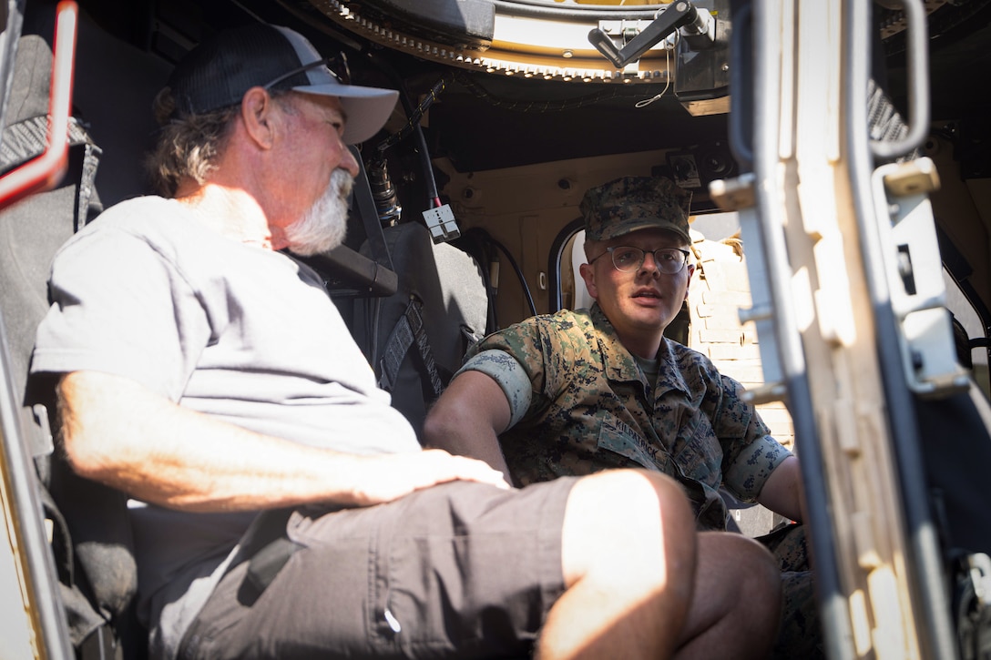 U.S. Marine Corps Lance Cpl. Harry Kilpatrick, a motor transport operator and a Florida native with I Marine Expeditionary Force Support Battalion, I MEF Information Group, interacts with a local during the Fallbrook Summer Nights event, at Fallbrook, California, July 19, 2025. I MIG Marines supported the event as part of community engagement efforts, fostering relationships between local residents and U.S. service members. (U.S. Marine Corps photo by Lance Cpl. Fabian Ortiz)