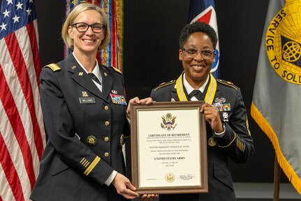 Col. Michelle M. Williams, U.S. Army Financial Management Command commander, left, presents Master Sgt. Candace M. Davis, USAFMCOM Operational Support Team senior financial management systems instructor, with a certificate of retirement at the Maj. Gen. Emmett J. Bean Federal Center April 11, 2025. A native of Augusta, Georgia, Davis enlisted in the Army as a financial management specialist in October 2002. (U.S. Army photo by Mark R. W. Orders-Woempner)