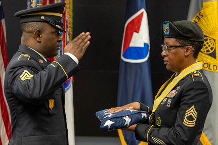 Sgt. 1st Class Deterrance A. Brown, U.S. Army Financial Management Command Operational Support Team senior financial management systems instructor, salutes an American flag after presenting it to Master Sgt. Candace M. Davis, USAFMCOM OST senior financial management systems instructor, during Davis’ retirement ceremony at the Maj. Gen. Emmett J. Bean Federal Center April 11, 2025. A native of Augusta, Georgia, Davis enlisted in the Army as a financial management specialist in October 2002. (U.S. Army photo by Mark R. W. Orders-Woempner)