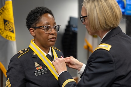 Col. Michelle M. Williams, U.S. Army Financial Management Command commander, right, presents Master Sgt. Candace M. Davis, USAFMCOM Operational Support Team senior financial management systems instructor, a Meritorious Service Medal at the Maj. Gen. Emmett J. Bean Federal Center April 11, 2025. A native of Augusta, Georgia, Davis enlisted in the Army as a financial management specialist in October 2002. (U.S. Army photo by Mark R. W. Orders-Woempner)