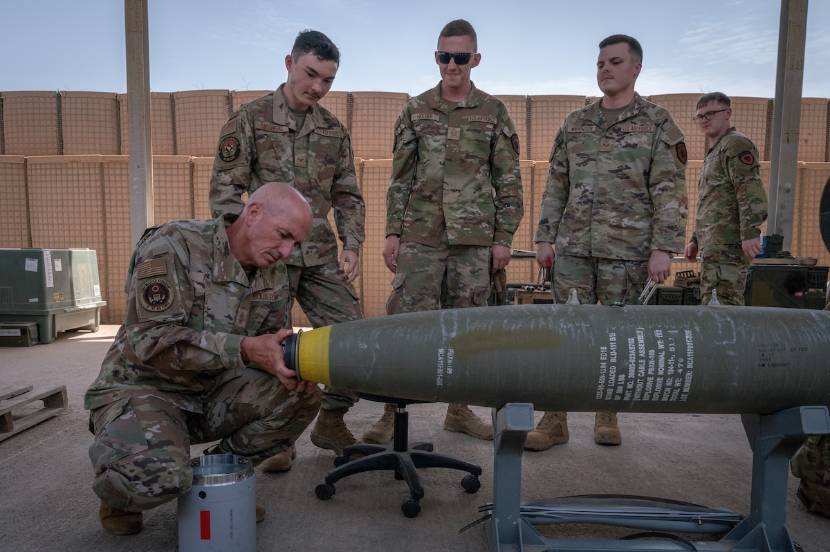 Chief Master Sgt. of the Air Force David Flosi assists munitions Airmen