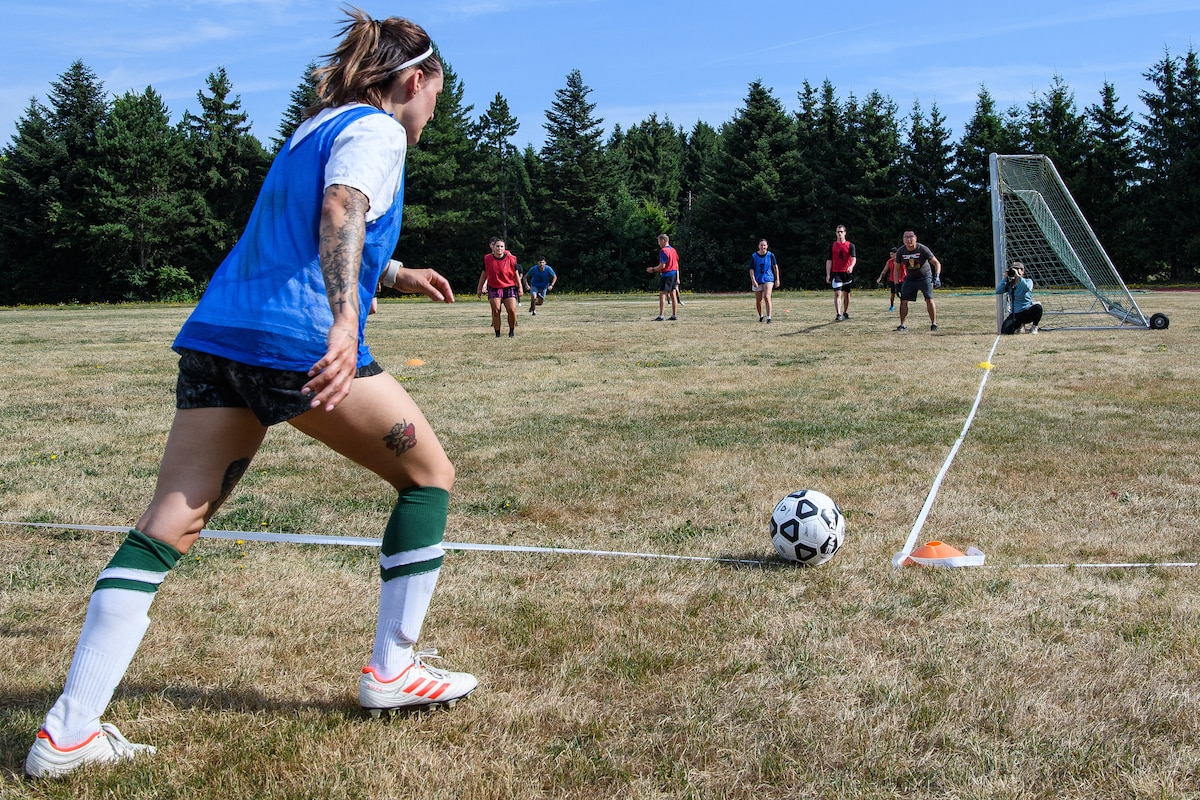 A woman takes a corner kick during a soccer game.